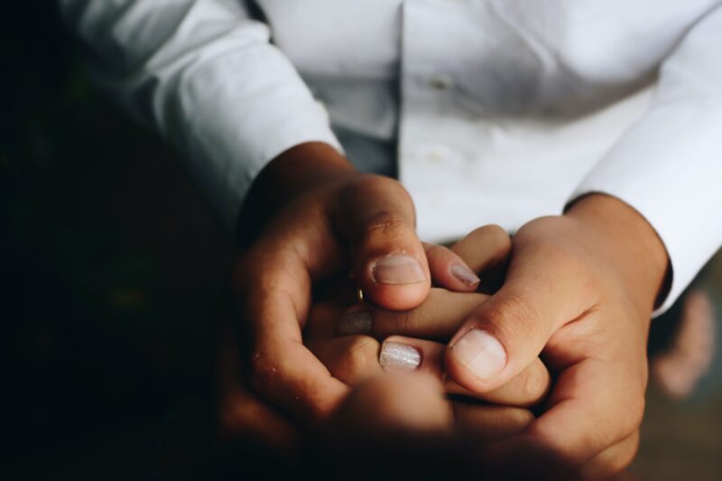 Close up image of two people holding hands
