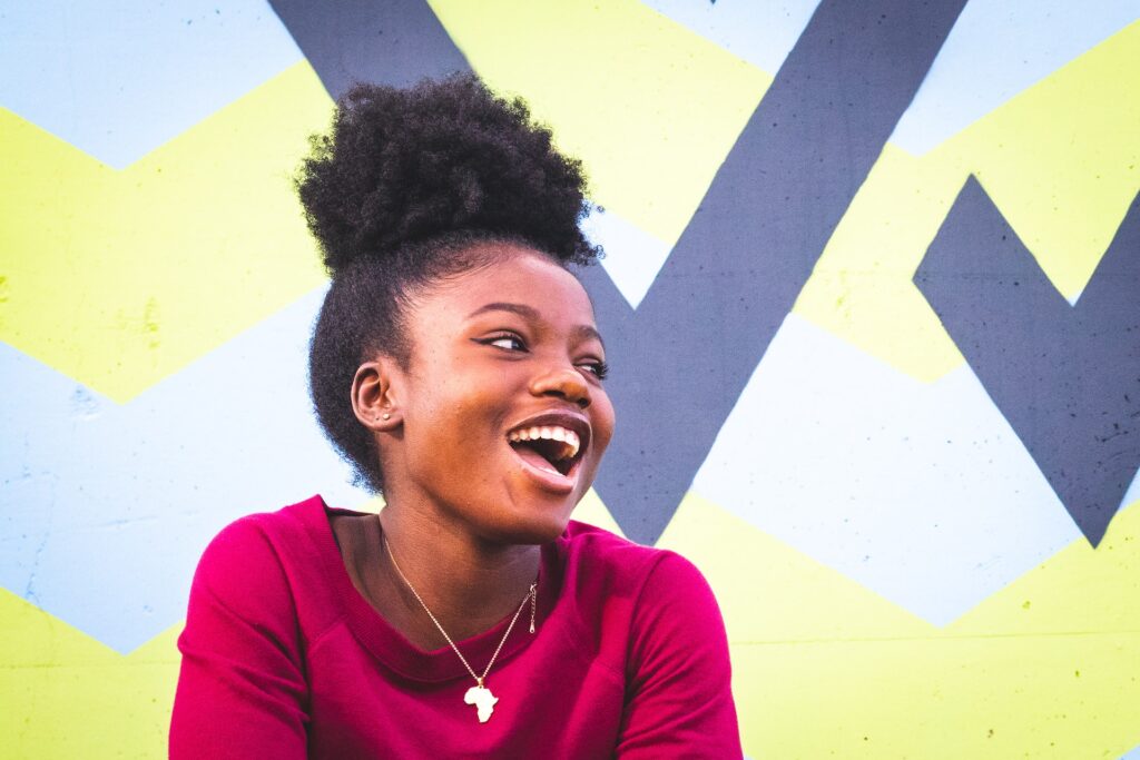 A smiling black woman against a colorful background