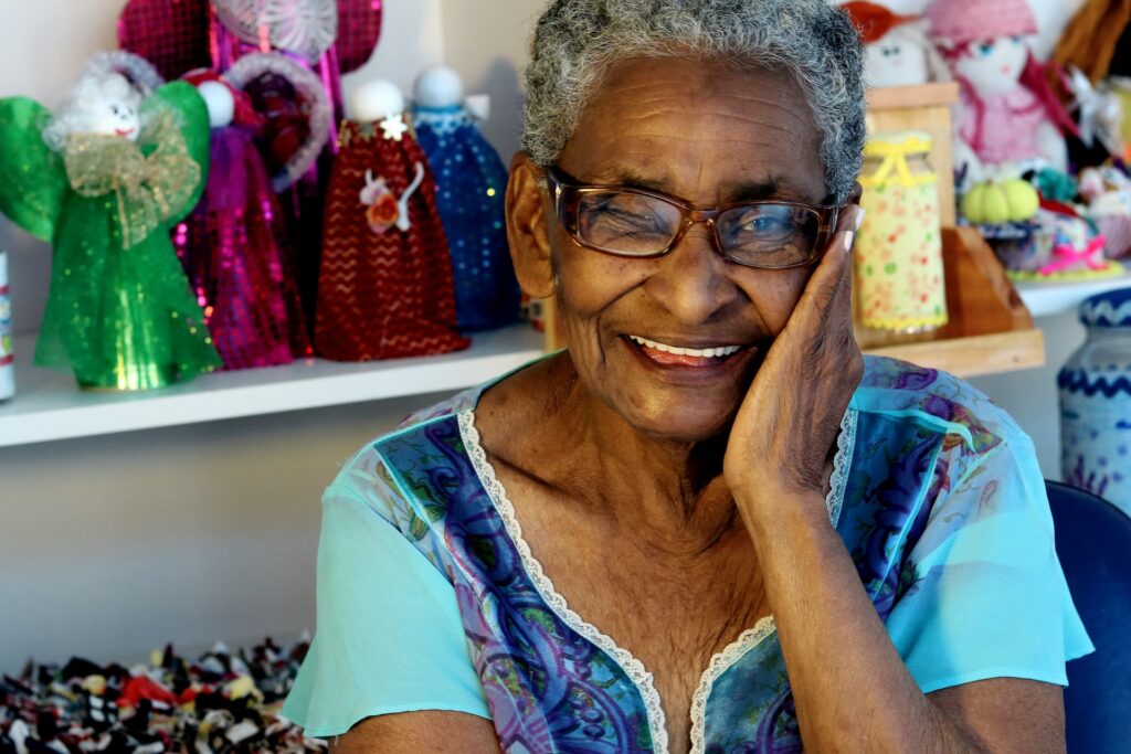 A senior black woman smiling at the camera